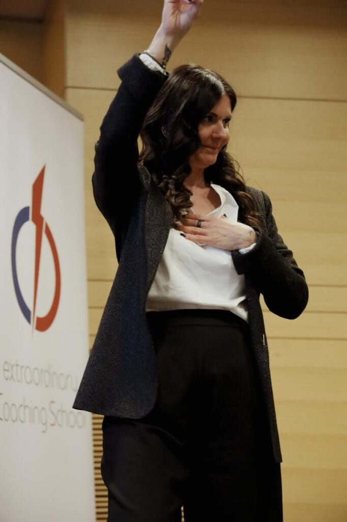 Laura con mano sul petto e braccio sollevato